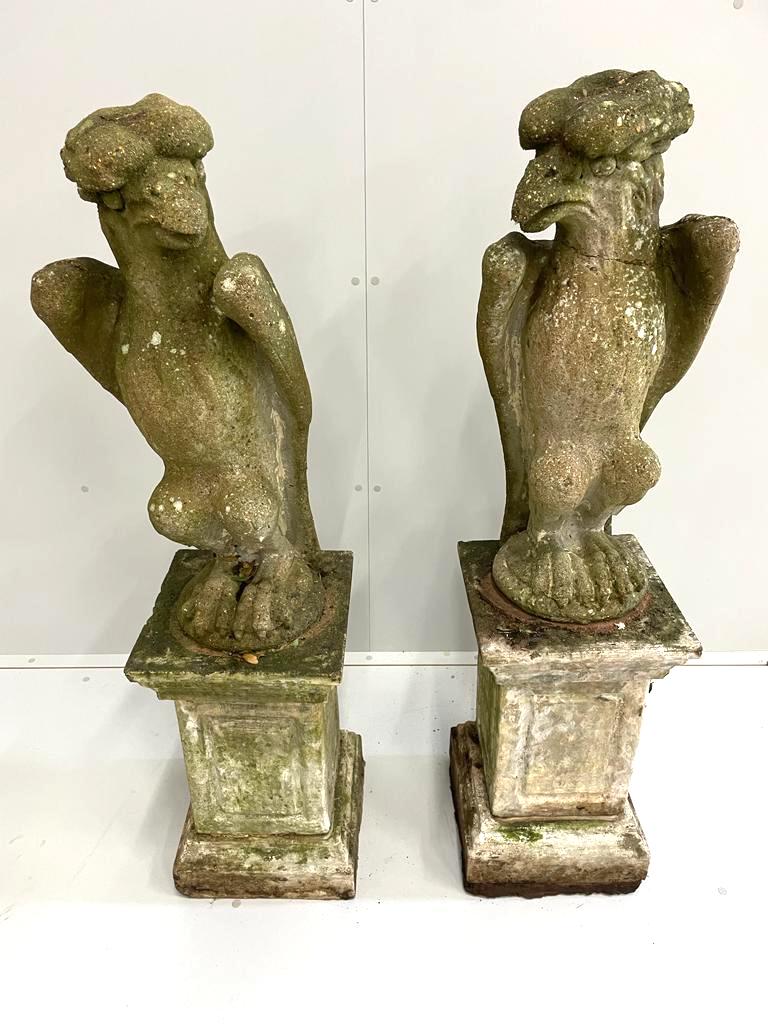 A pair of reconstituted stone models of eagles, on square plinths, height 125cm (eagle head cracked)